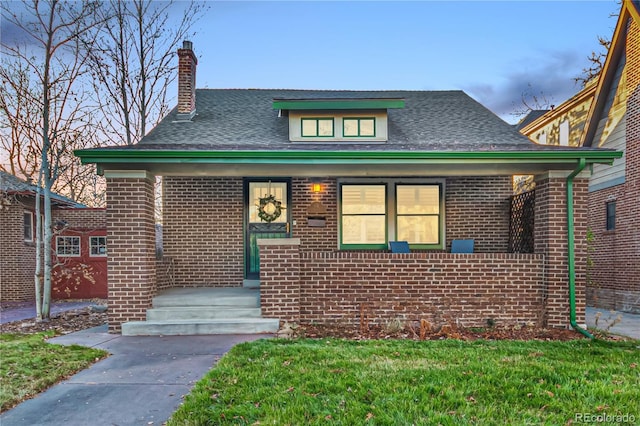 view of front of home with a porch and a front yard