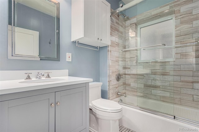 full bathroom featuring vanity, enclosed tub / shower combo, and toilet