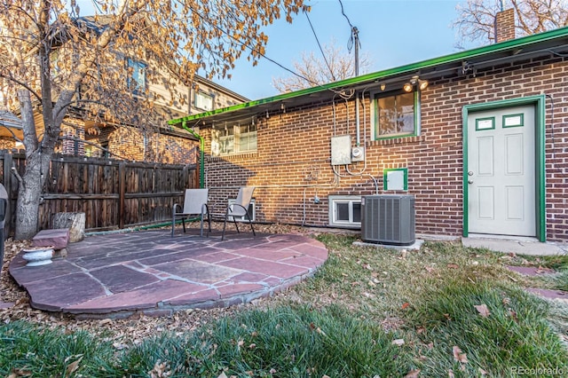 rear view of property with central AC unit and a patio