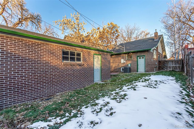 snow covered house with central air condition unit