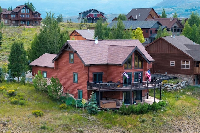 back of property with a deck with mountain view