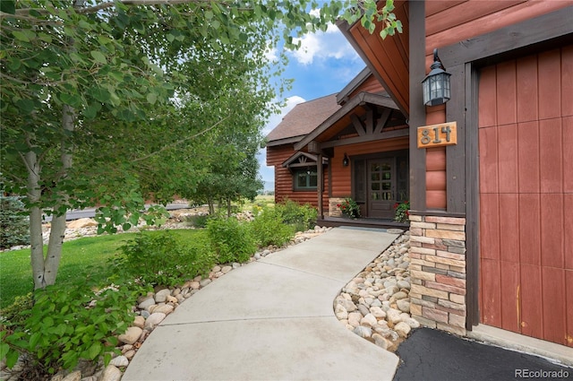 entrance to property featuring a lawn