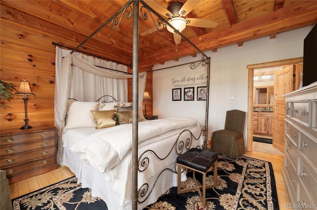 bedroom with light hardwood / wood-style floors, beamed ceiling, wooden ceiling, and ceiling fan