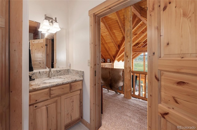 bathroom featuring vanity, wooden ceiling, and vaulted ceiling with beams