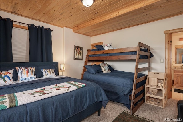 bedroom featuring wood ceiling, carpet floors, and ensuite bath