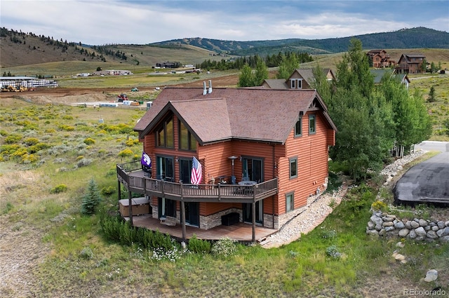 back of property with a deck with mountain view