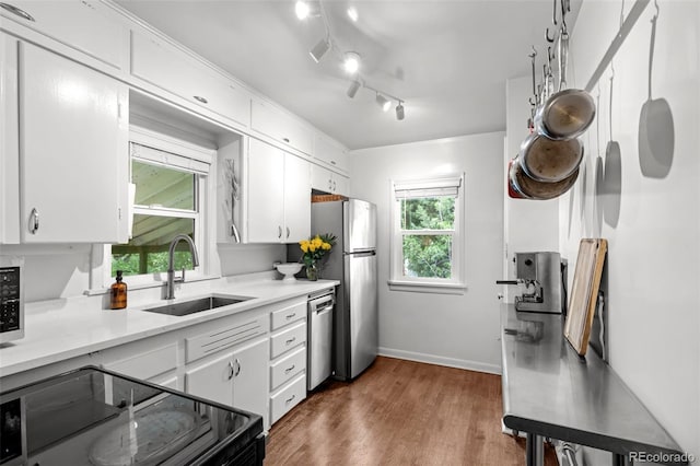3231 S Elati St, Englewood, CO 80110 - kitchen featuring a sink, stainless steel appliances, white cabinetry, and dark wood-style flooring