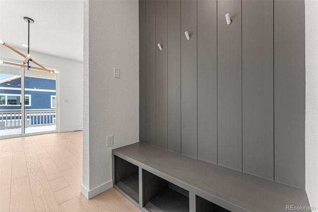 mudroom with a chandelier and light wood-type flooring