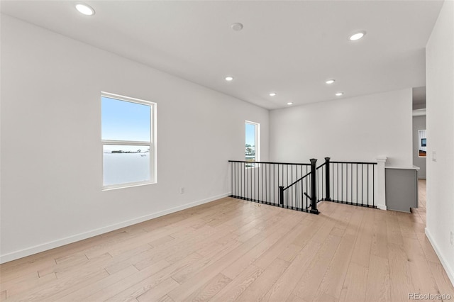 spare room featuring light hardwood / wood-style floors and a healthy amount of sunlight