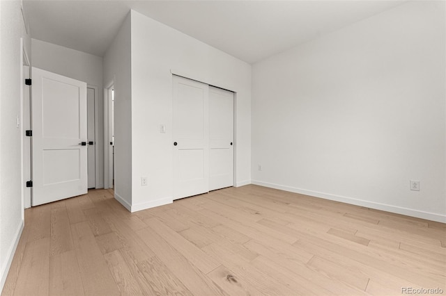 unfurnished bedroom with a closet and light wood-type flooring