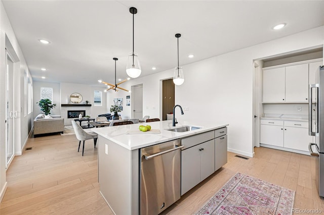 972 Arapahoe Cir, Louisville, CO 80027 - kitchen featuring light wood-type flooring, a sink, appliances with stainless steel finishes, and white cabinets