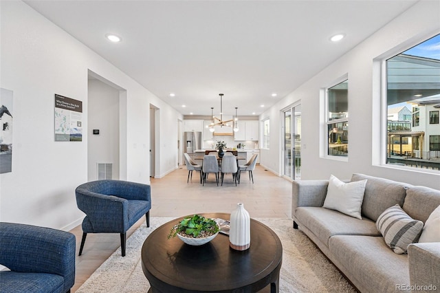 972 Arapahoe Cir, Louisville, CO 80027 - living area with recessed lighting, plenty of natural light, light wood finished floors, and a notable chandelier