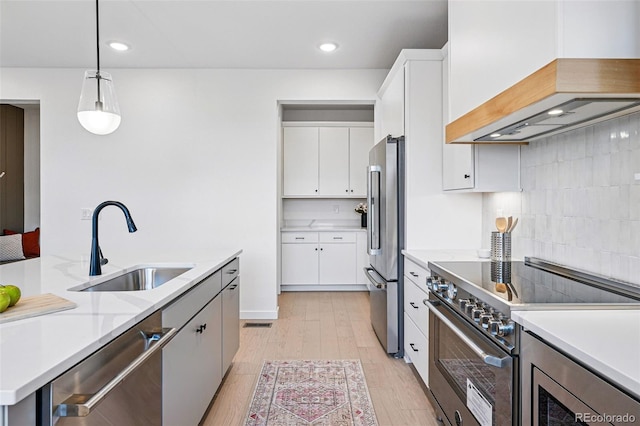 972 Arapahoe Cir, Louisville, CO 80027 - kitchen featuring appliances with stainless steel finishes, a sink, light countertops, light wood-type flooring, and custom exhaust hood