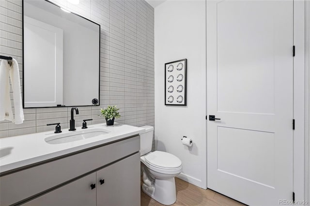 972 Arapahoe Cir, Louisville, CO 80027 - bathroom featuring vanity, toilet, tile walls, decorative backsplash, and wood finished floors