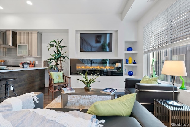 living room featuring wood-type flooring and built in features