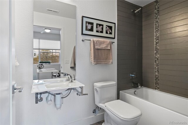 bathroom with tiled shower / bath and toilet