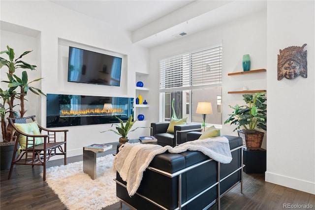 living room featuring built in shelves and dark hardwood / wood-style floors