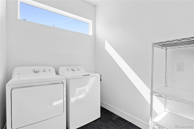 clothes washing area featuring washing machine and dryer and dark tile patterned floors