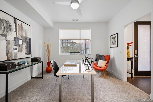 carpeted office space with ceiling fan