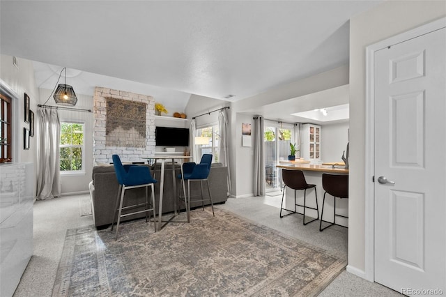 kitchen featuring a wealth of natural light, a breakfast bar, and carpet floors