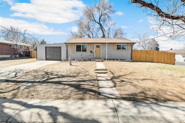 ranch-style house featuring a garage, driveway, and fence