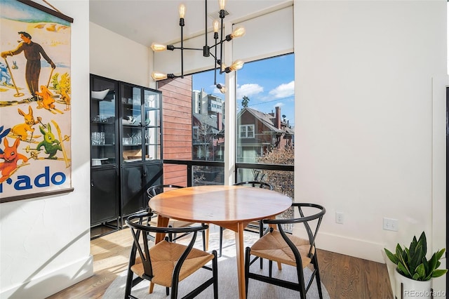 dining area featuring hardwood / wood-style floors and a chandelier