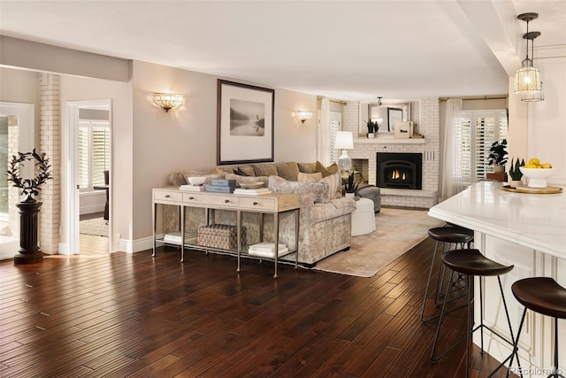 living room with dark wood-type flooring and a fireplace