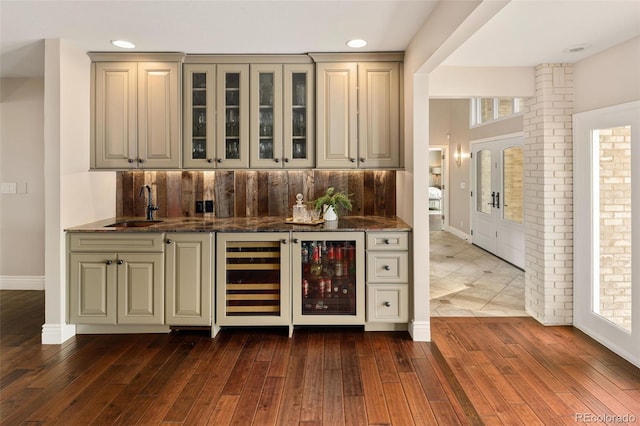 bar featuring cream cabinets, dark wood-type flooring, dark stone countertops, and wine cooler