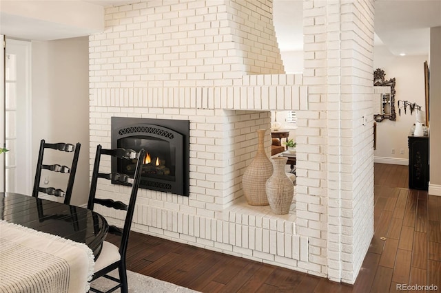 interior space featuring hardwood / wood-style flooring and a brick fireplace