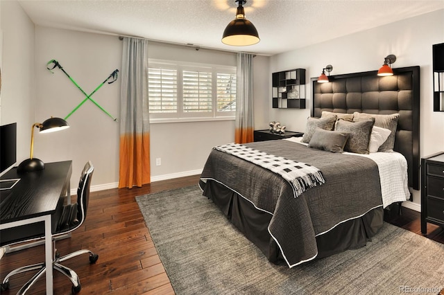 bedroom with dark hardwood / wood-style floors and a textured ceiling