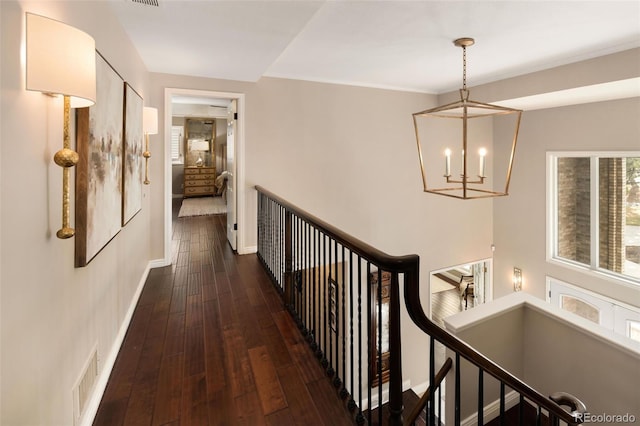 hall featuring an inviting chandelier and dark hardwood / wood-style flooring