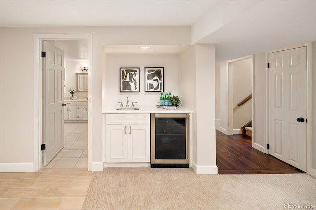 bar with wine cooler, white cabinetry, sink, and light tile patterned floors