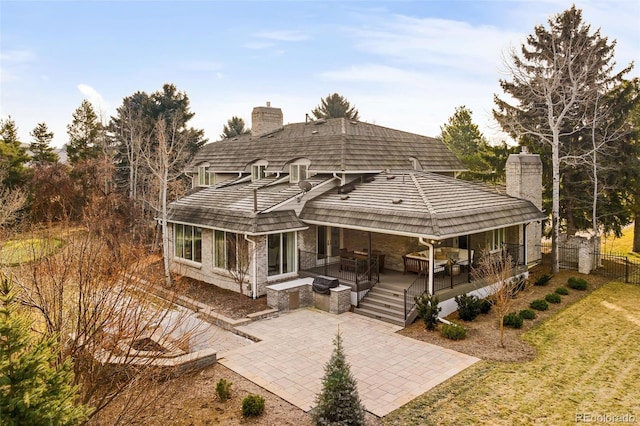 rear view of property featuring an outdoor hangout area, a patio area, and a lawn