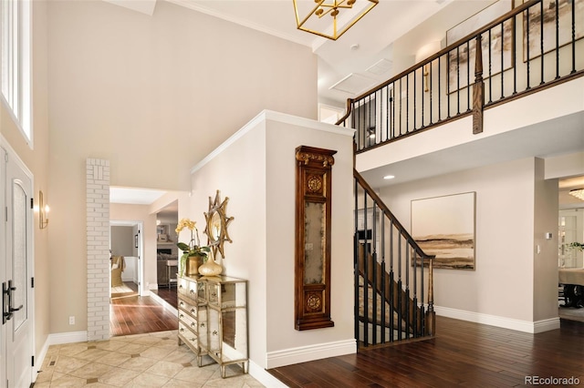 entrance foyer featuring crown molding, hardwood / wood-style flooring, and a high ceiling