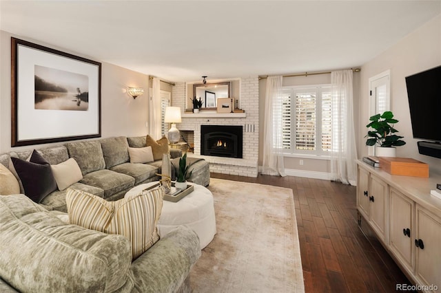 living room featuring a brick fireplace and dark hardwood / wood-style flooring