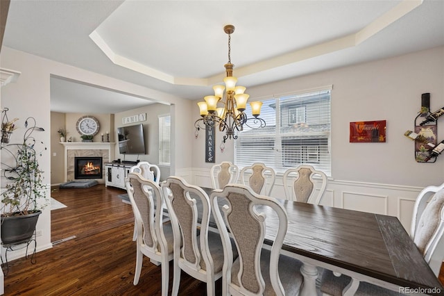 20366 Spruce Point Pl, Parker, CO 80134 - dining room featuring a chandelier, a tray ceiling, a high end fireplace, wainscoting, and a decorative wall