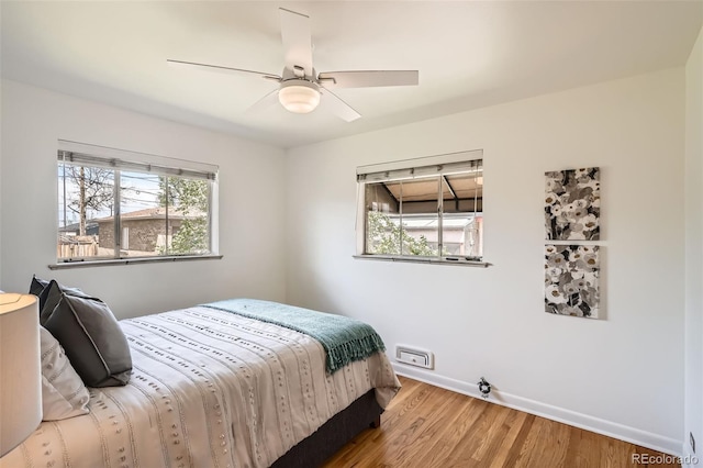 bedroom featuring baseboards, ceiling fan, and wood finished floors