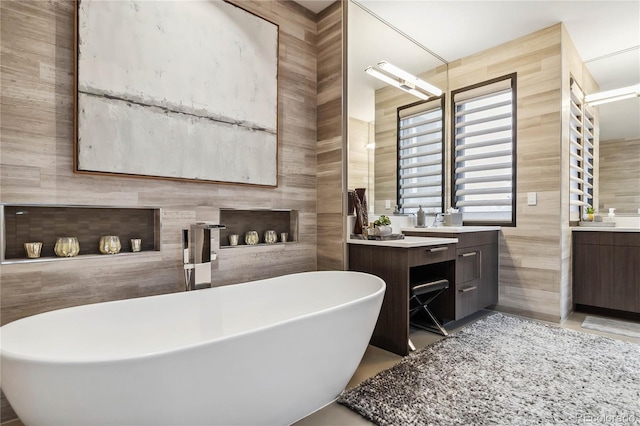 full bath featuring a freestanding bath, tile walls, and vanity