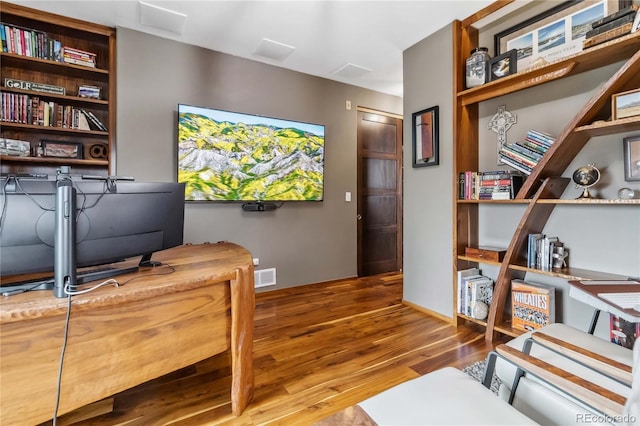 office space featuring visible vents, baseboards, and wood finished floors