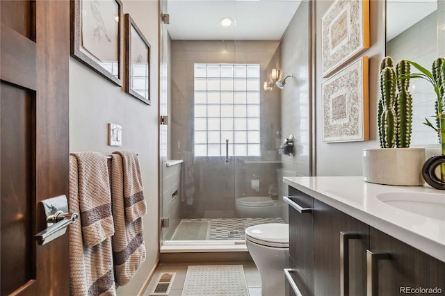 full bathroom with vanity, a shower stall, toilet, and visible vents