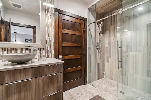 bathroom with visible vents, vanity, and a shower stall