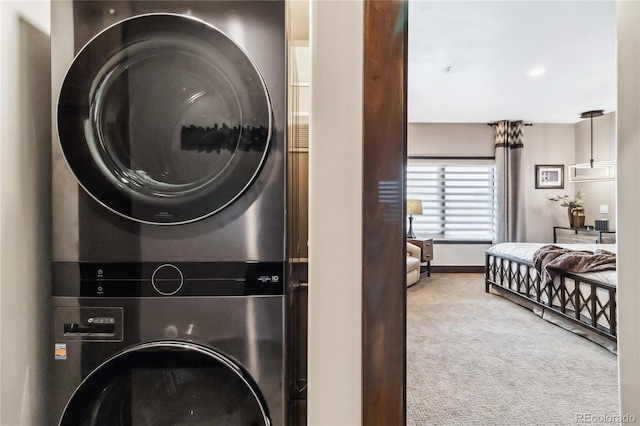 laundry room featuring laundry area, carpet flooring, and stacked washing maching and dryer