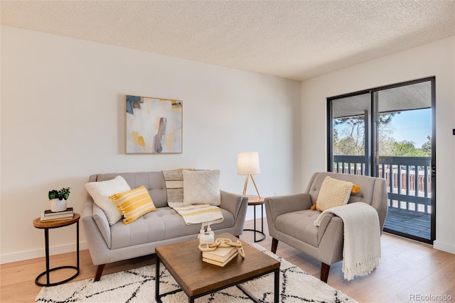 8335 Fairmount Dr Unit 7-208, Denver, CO 80247 - living room featuring light wood-style flooring, baseboards, and a textured ceiling