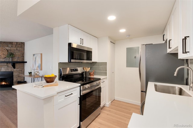 8335 Fairmount Dr Unit 7-208, Denver, CO 80247 - kitchen featuring stainless steel appliances, light wood finished floors, decorative backsplash, a sink, and white cabinets