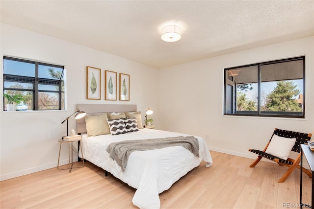 8335 Fairmount Dr Unit 7-208, Denver, CO 80247 - bedroom with multiple windows, light wood-type flooring, and baseboards