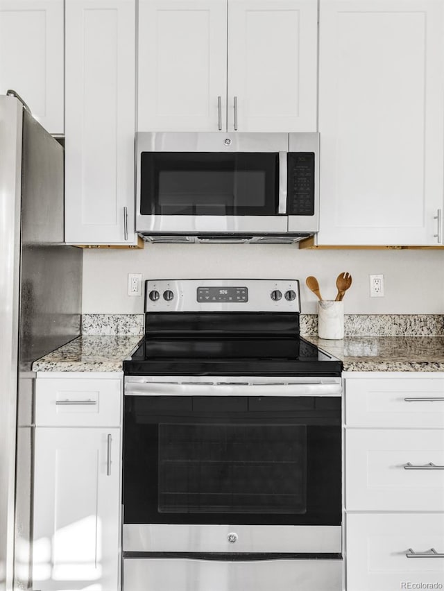 kitchen featuring light stone countertops, white cabinets, and appliances with stainless steel finishes