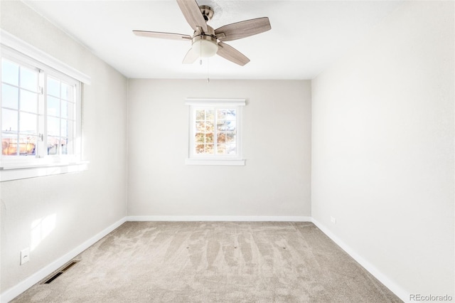 carpeted empty room featuring a healthy amount of sunlight and ceiling fan