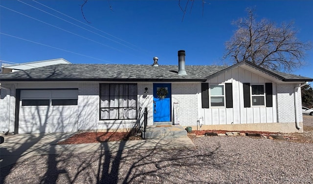 ranch-style house featuring a garage, roof with shingles, brick siding, and board and batten siding