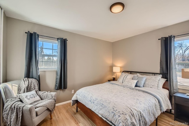 bedroom with light wood finished floors and baseboards