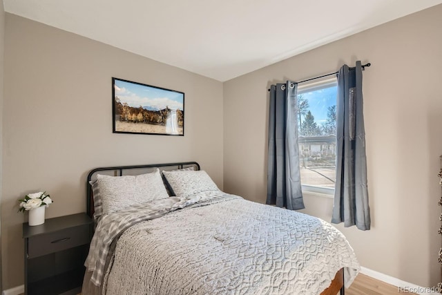 bedroom with baseboards and wood finished floors